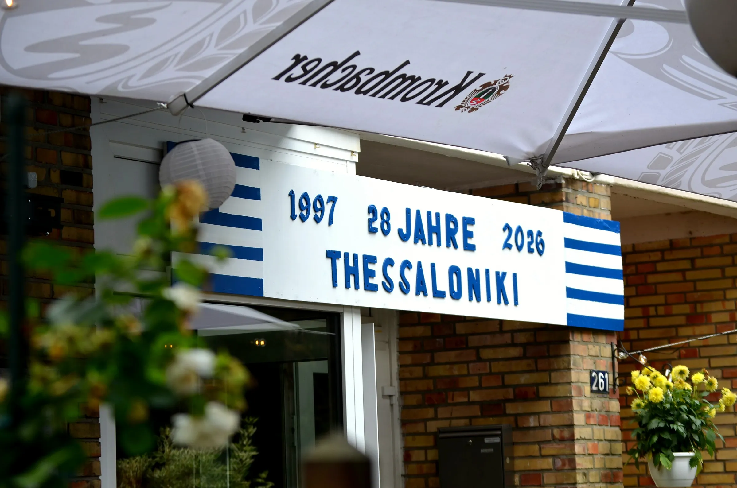 Eingang des Restaurants mit dem blau-weißen Jubiläumsbanner: 1997, 28 Jahre, 2026