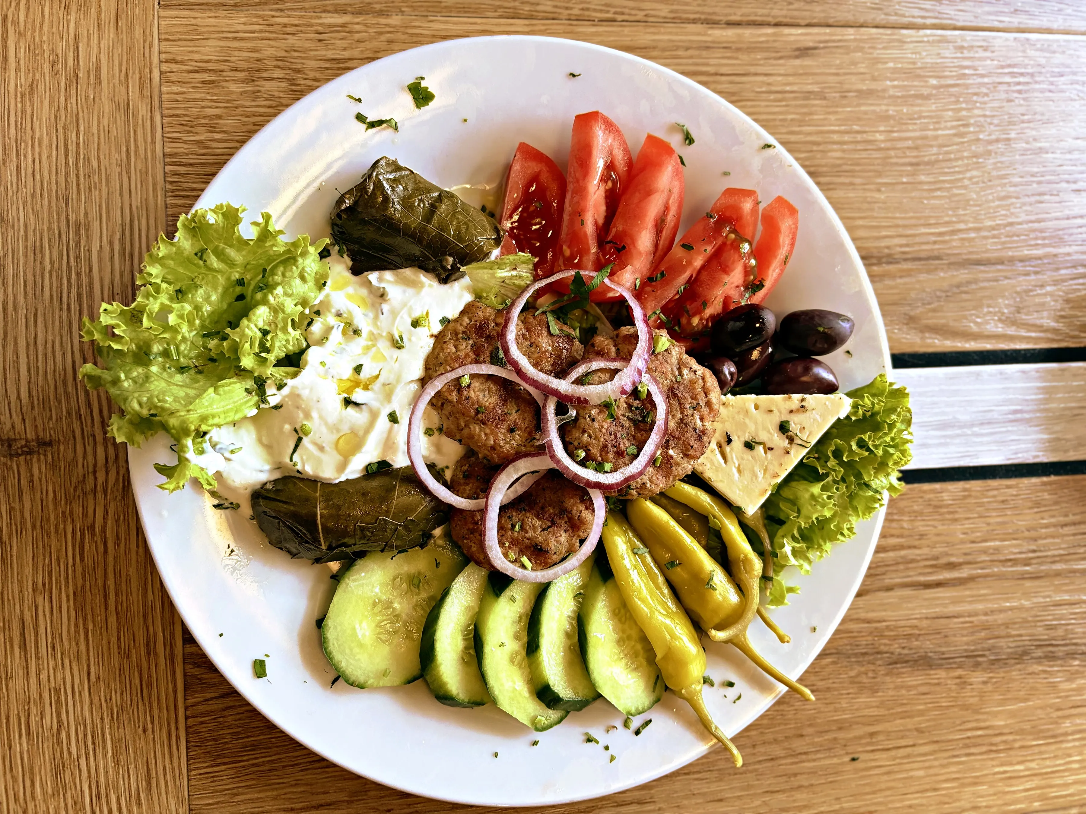 Ouzo-Teller mit Keftedes, Dolmadakia, Zaziki, Tomaten und Gurken