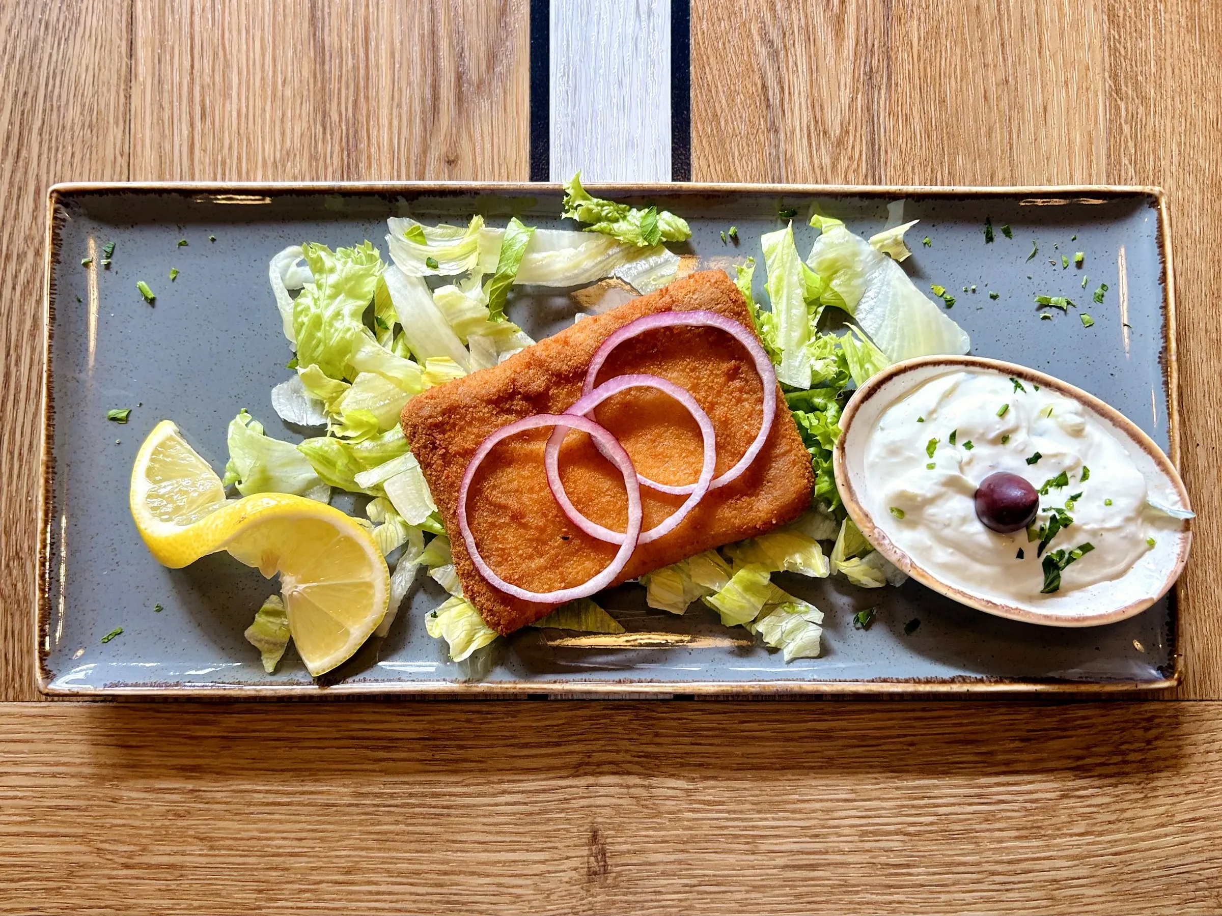 Panierter Saganaki mit Zwiebelringen und Zaziki